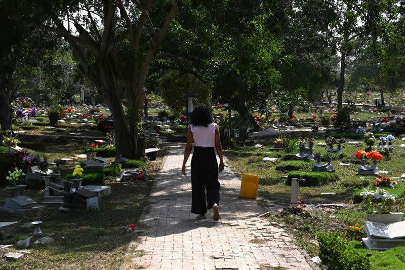 Claudia Patricia Fortich, widow of late oil tanker captain Jaime Herrera Orozco, who was murdered on his ship while anchored off Venezuela, walks in the middle of a graveyard, in Cartagena