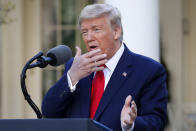 President Donald Trump holds his hand to his face as he talks about masks during a briefing about the coronavirus in the Rose Garden of the White House, Monday, March 30, 2020, in Washington. (AP Photo/Alex Brandon)