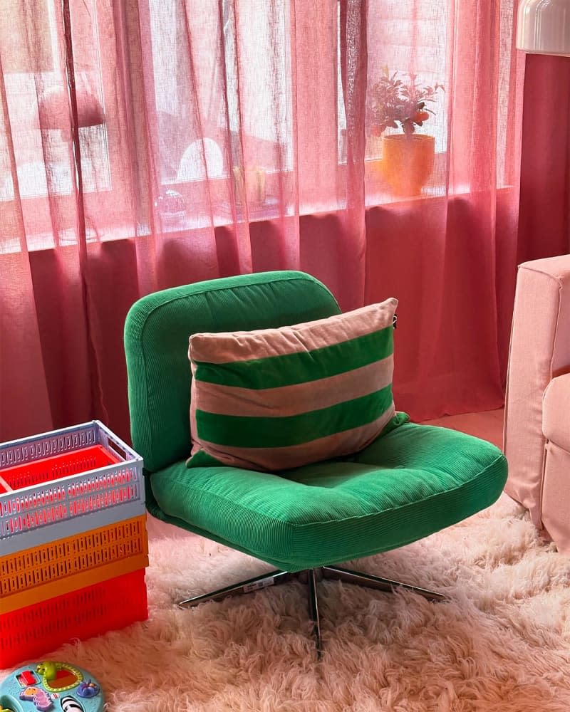 Striped decorative pillows on a green accent chair.