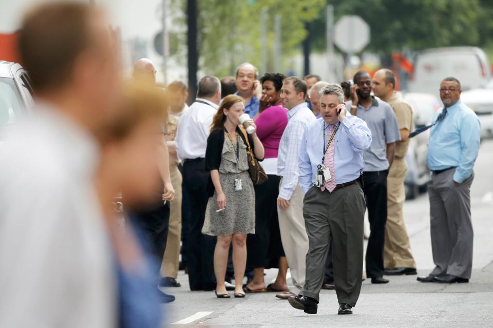 Employees look for more information as police respond to reports of a shooting and subsequent lockdown at the U.S. Navy Yard in Washington July 2, 2015. (REUTERS/Jonathan Ernst)