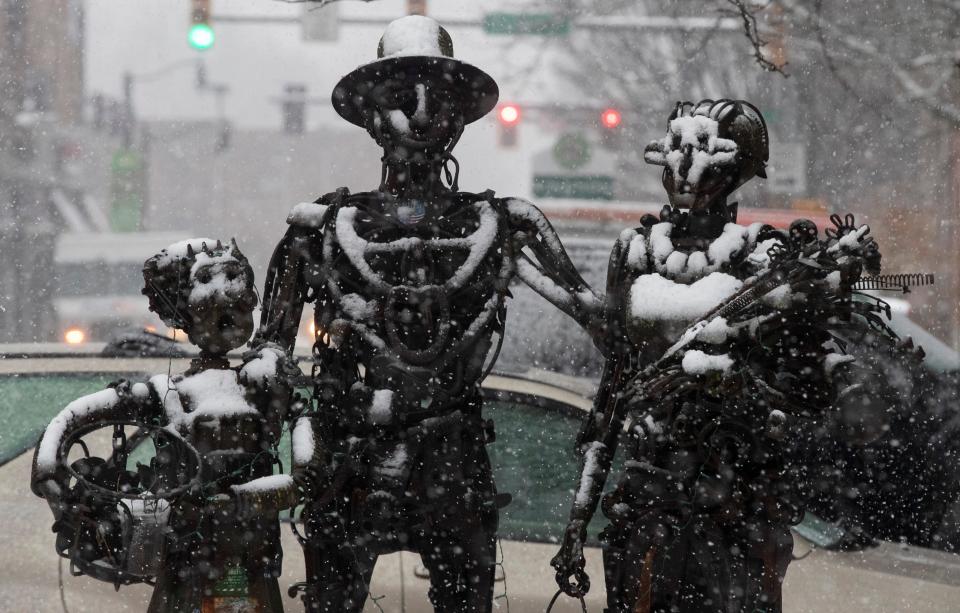 Snow accumulates on a statue, Wednesday, Jan. 25, 2023, in Lafayette, Ind. 