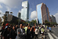 People gather in the street after evacuating their office buildings during an earthquake drill, commemorating the 34th anniversary of the 1985 earthquake, in Mexico City, Thursday, Sept. 19, 2019. The 8.1-magnitude earthquake killed as many as 10,000 and left thousands homeless. The date also commemorates the 2017 earthquake that rattled the city killing hundreds. (AP Photo/Eduardo Verdugo)