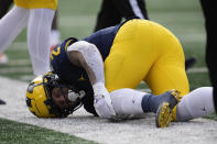 Michigan running back Blake Corum (2) grabs at his knee after being injured on a run against Illinois in the first half of an NCAA college football game in Ann Arbor, Mich., Saturday, Nov. 19, 2022. (AP Photo/Paul Sancya)
