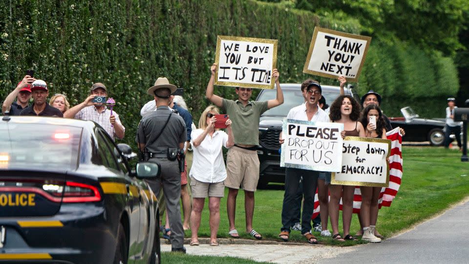 People hold signs calling for President Joe Biden to step aside this upcoming election in East Hampton, New York, as Biden's motorcade passes by on Saturday, June 29, 2024. - Haiyun Jiang/The New York Times/Redux