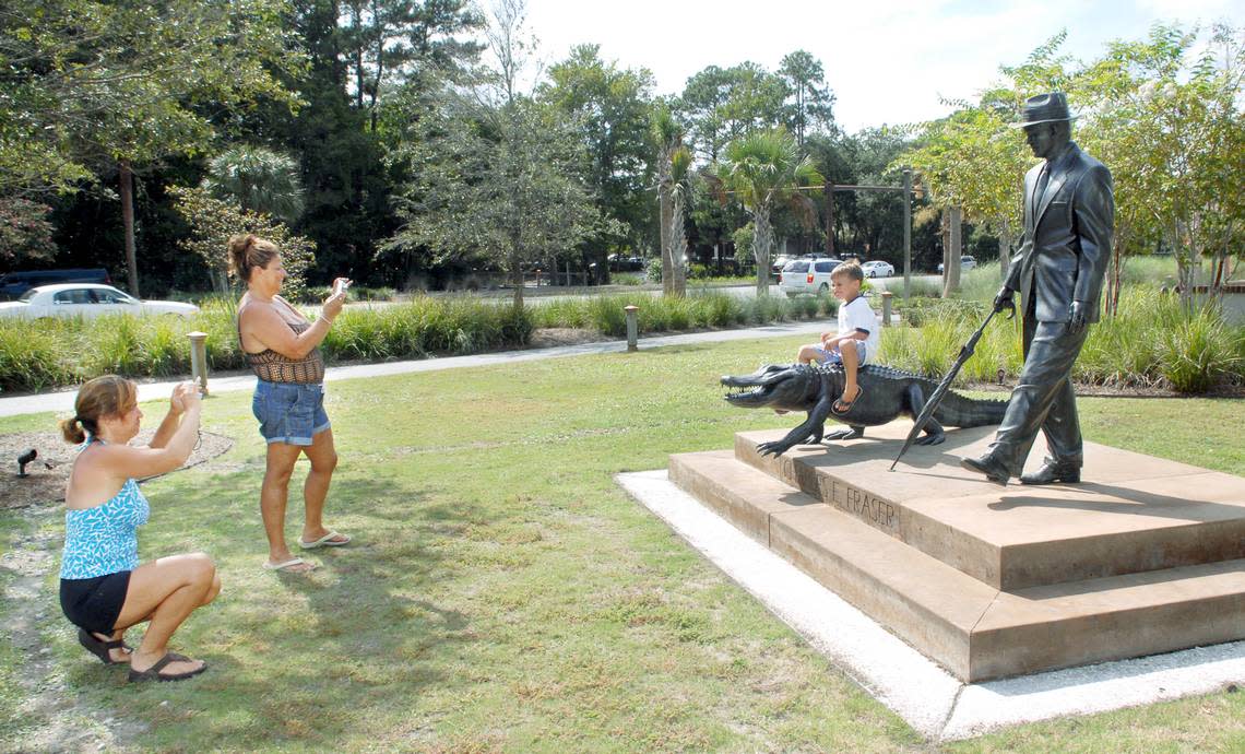 From left, Jennifer Pavelka and Janice Tuozzo photograph Jennifer’s son, Jack, 6, as he poses on the statue of Charles Frasier walking with an alligator at Compass Rose Park on Pope Avenue on Monday. The visitors from New York, who were taking a break from biking along Pope Avenue, said they were impressed with the park, which is one of many improvements the town has made in recent years in the Pope Avenue, Palmetto Bay Road, Dunnagans Alley and Arrow Road areas.