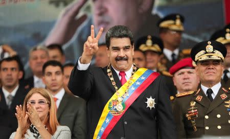 Venezuela's President Nicolas Maduro gestures during a military parade to celebrate the 197th anniversary of the Battle of Carabobo, next to his wife Cilia Flores and Venezuela's Defense Minister Vladimir Padrino Lopez, in Campo de Carabobo, Venezuela June 24, 2018. Miraflores Palace/Handout via REUTERS A