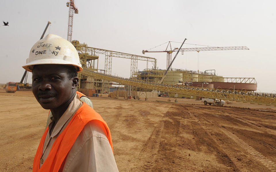 A worker poses in front of the construction site of the Essakane gold mine, the biggest gold mine of the country under construction in the north, which will produce 12 tons of gold yearly, according to people in charge, on May 12, 2010 in Essakane. Burkina Faso more than doubled its gold production in 2009, reaching more than 11 tonnes, according to Prime Minister Tertius Zongo.  Several mining companies from Canada, South Africa, Australia, and Russia have acquired mining rights. Source: ISSOUF SANOGO/AFP/Getty Images)