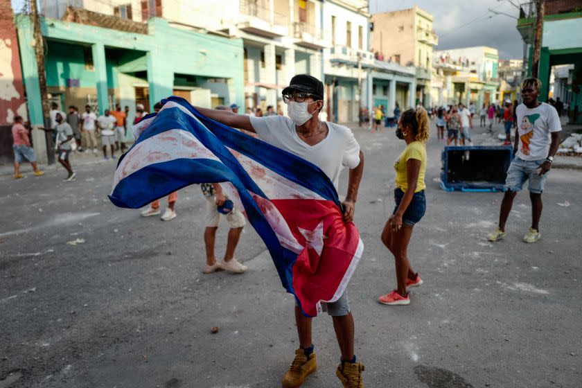 A man waves a Cuban flag during a demonstration against the government of Cuban President Miguel Diaz-Canel in Havana, on July 11, 2021. - Thousands of Cubans took part in rare protests Sunday against the communist government, marching through a town chanting "Down with the dictatorship" and "We want liberty." (Photo by ADALBERTO ROQUE / AFP) (Photo by ADALBERTO ROQUE/AFP via Getty Images)