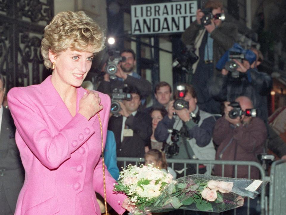 princess diana wearing a pink jacket in front of the paparazzi