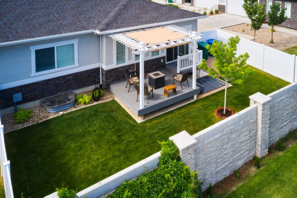 A pergola is used as an awning in someone's backyard. 