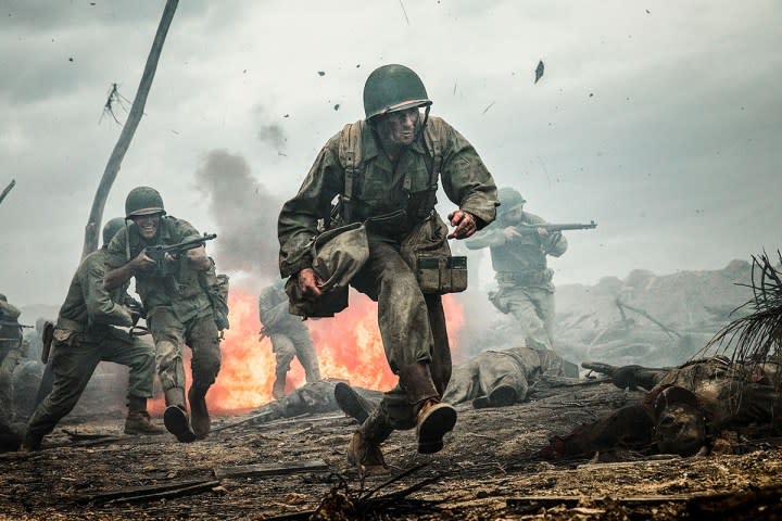 A soldier runs through a battlefield.