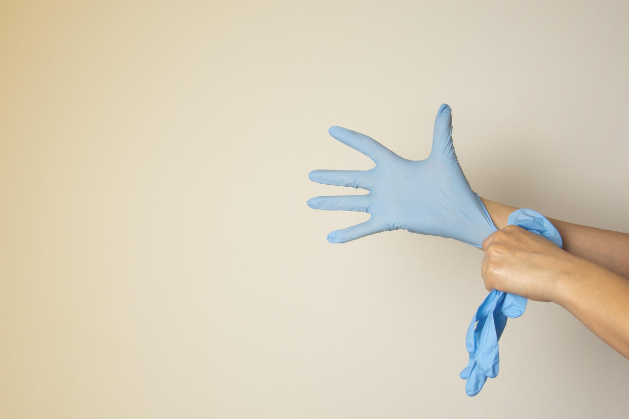 To safely take off a glove, you need to invert it. If your bare hand is touching the glove, you could be spreading germs.&nbsp; (Photo: Gingagi via Getty Images)