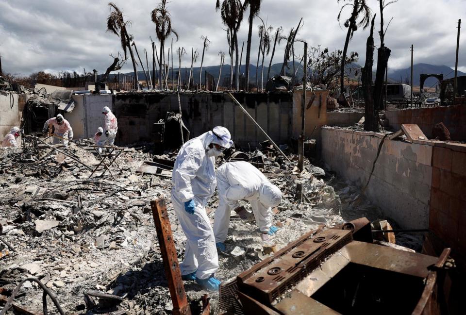 PHOTO: Displaced residents Caroline and William Anthony search for personal items in the rubble of the wildfire destroyed home where they lived, as volunteers from Samaritan's Purse assist, Oct. 5, 2023 in Lahaina, Hawaii.  (Mario Tama/Getty Images)