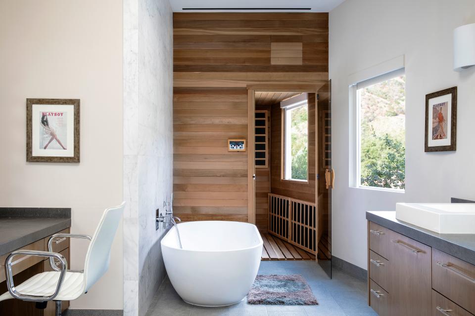 “I am not a huge bath person,” says Handler. “I am not British so I don’t have an affinity [for it] the same way others do, but because of this tub I have taken more baths than I probably ever would. It’s nice to be able to sit up in a tub.” The master suite bathroom also includes an infrared sauna the comedian had installed. “I used to have a remote one, but now I have this one, with a bench in it. I like to lie down or read a book.” Vintage Playboy covers decorate the walls and the window looks out on to treetops. “It’s like being in a solarium,” Handler says. “There’s only greenery surrounding my house, which is a lot like [my experience] growing up in [Livingston] New Jersey.” The room also features a two-person shower.