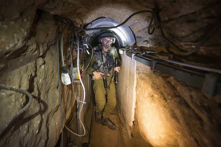 An Israeli army officer gives explanations to journalists during an army organised tour in a tunnel said to be used by Palestinian militants for cross-border attacks, July 25, 2014.REUTERS/Jack Guez/Pool