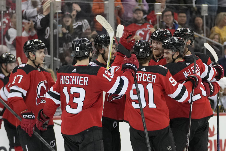 New Jersey Devils defenseman Dougie Hamilton, third from right, celebrates with his teammates after scoring the winning goal in overtime of an NHL hockey game, Tuesday, Jan. 24, 2023, in Newark, N.J. The Devils won 3-2. (AP Photo/Mary Altaffer)