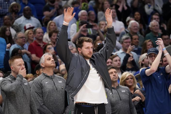 Dallas Mavericks guard Luka Doncic gestures as he watches his team play in the final seconds of an NBA basketball game against the Sacramento Kings in Dallas, Saturday, March, 5, 2022. The Mavericks won 114-113. (AP Photo/Tony Gutierrez)