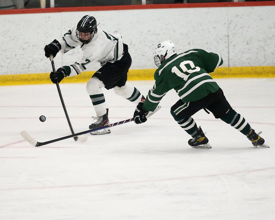 Duxbury's Aiden Harrington looks to clear the puck away from Canton’s Brian Middleton during second period action of their game in the Division 2 state semifinal at Gallo Ice Arena in Bourne on Saturday, March 11, 2023.