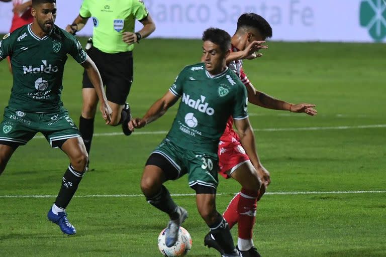 Fausto Montero, mediocampista de Sarmiento, domina la pelota ante la marca de Acevedo, N° 5 de Unión