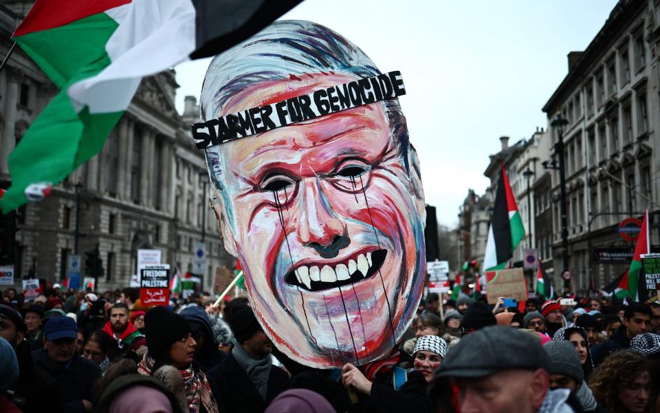 Pro-Palestinian activists and supporters carry a giant mask of Britain's main opposition Labour Party leader, Keir Starmer