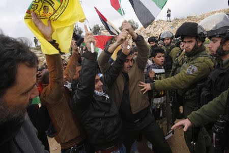 Palestinians argue with Israeli border policemen and soldiers during a demonstration against the closure of the main road in Jabaa area south of the West Bank city of Bethlehem January 17, 2015. REUTERS/Mussa Qawasma