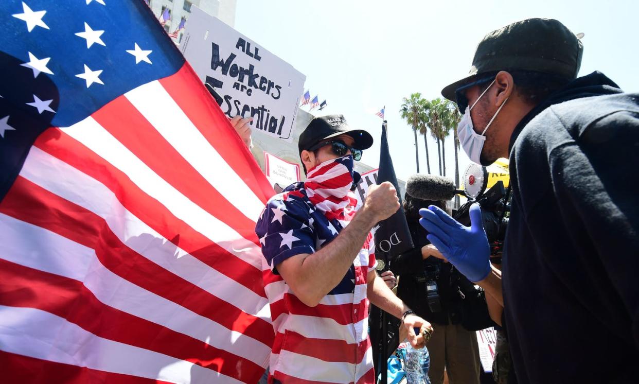 <span class="caption">A protestor argues with a counter-protestor in Los Angeles on May 1, 2020.</span> <span class="attribution"><a class="link " href="https://www.gettyimages.com/detail/news-photo/protestor-argues-with-a-counter-protestor-in-front-of-the-news-photo/1211485812?adppopup=true" rel="nofollow noopener" target="_blank" data-ylk="slk:FREDERIC J. BROWN/AFP via Getty Images;elm:context_link;itc:0;sec:content-canvas">FREDERIC J. BROWN/AFP via Getty Images</a></span>
