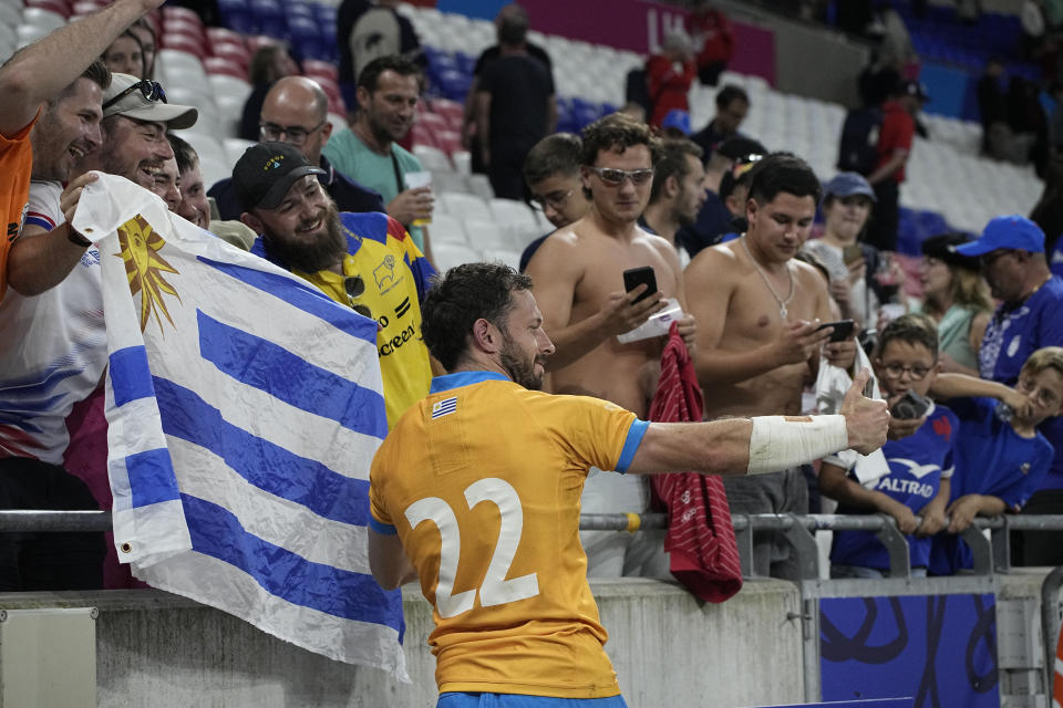 Uruguay's Felipe Berchesi takes a selfie with fans after the Rugby World Cup Pool A match between Uruguay and Namibia at the OL Stadium in Lyon, France, Wednesday, Sept. 27, 2023. (AP Photo/Laurent Cipriani)