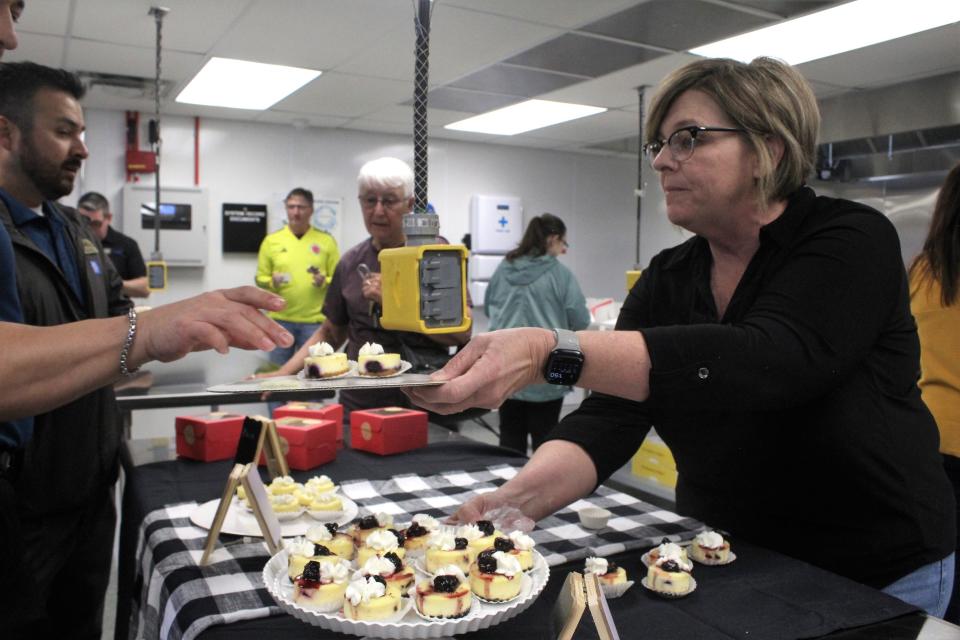 Gaynell Pritts of Whippy Cakes hands some cheesecake to a customer during the grand opening of Fuel Kitchens, Pueblo's first full-scale commissary kitchen, on Friday, March 1, 2024.