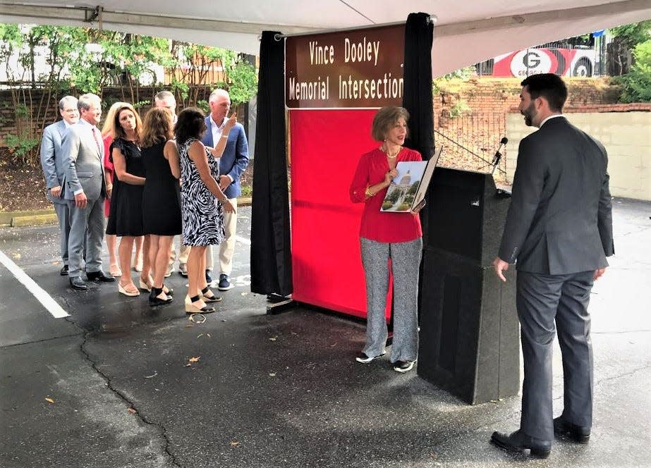 State Rep. Houston Gaines, far right, speaks with Barbara Dooley after the unveiling of a sign during a ceremony Monday at the corner of Broad and Lumpkin streets in Athens.