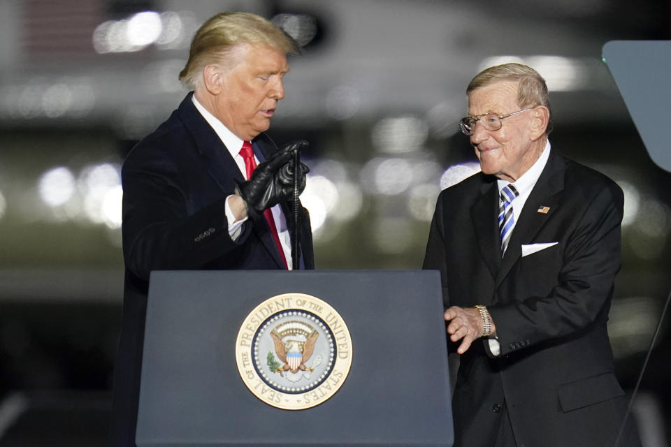 President Donald Trump, left, introduces former college football coach Lou Holtz during a campaign stop, Saturday, Oct. 31, 2020, at the Butler County Regional Airport in Butler, Pa. (AP Photo/Keith Srakocic)