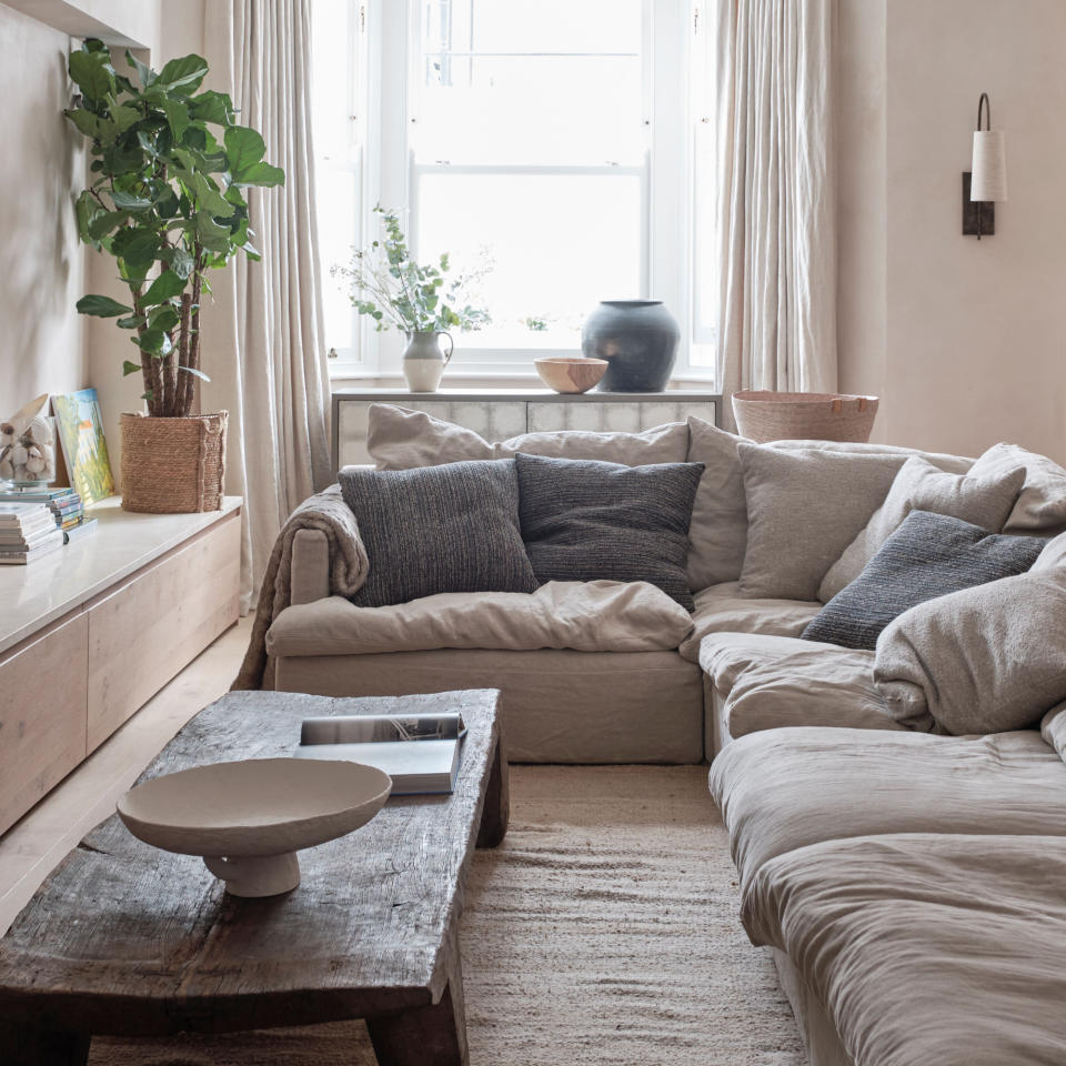 Neutral coloured sofa with grey scatter cushions in neutral living room