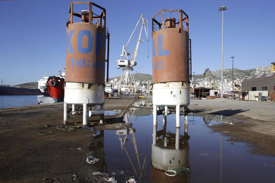 In this Monday, Feb. 10, 2014 photo tanks are reflected in a puddle on the docks in the depressed Perama area, on the fringes of Athens' port of Piraeus. For Perama, the ships have sailed. Until recently, this working class town at Athens’ western tip hosted some of the busiest shipyards in Greece, a maritime country with one of the world’s biggest shipping industries. Perama’s unemployment is among the worst in Greece, where the nationwide figure for November was 28 percent, according to the statistical authority on Thursday, Feb. 13, 2014. (AP Photo/Thanassis Stavrakis)