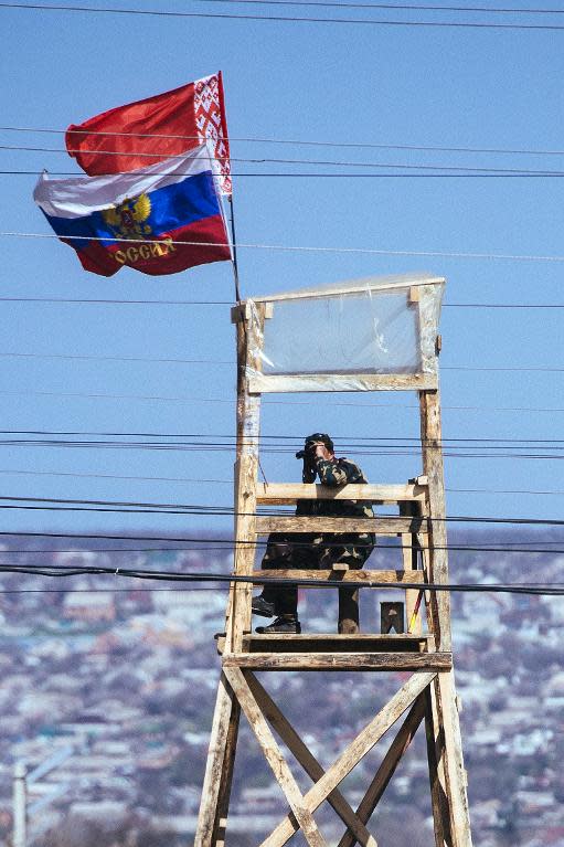 A pro-Russian activist stands guard at a watchtower outside the secret service building in the eastern Ukrainian city of Lugansk, which was taken over by pro-Russian separatists, on April 19, 2014