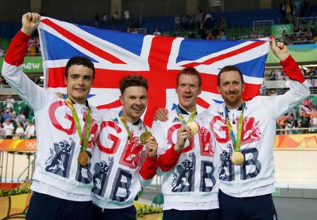 2016 Rio Olympics - Cycling Track - Victory Ceremony - Men's Team Pursuit Victory Ceremony - Rio Olympic Velodrome - Rio de Janeiro, Brazil - 12/08/2016. Steven Burke (GBR) of Britain, Owain Doull (GBR) of Britain, Ed Clancy (GBR) of Britain and Bradley Wiggins (GBR) of Britain pose with the gold medal and their country's flag. REUTERS/Eric Gaillard