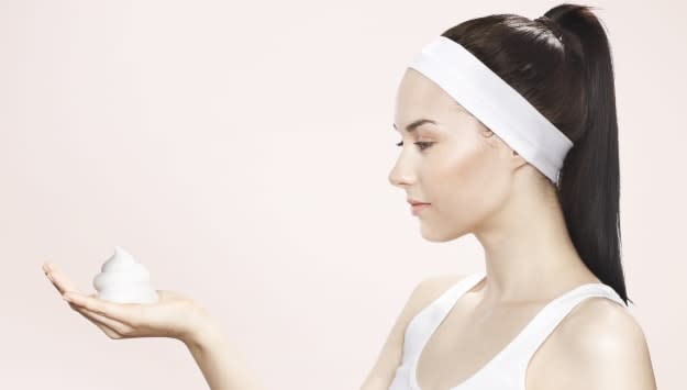 Young woman holding washing foam in her hands