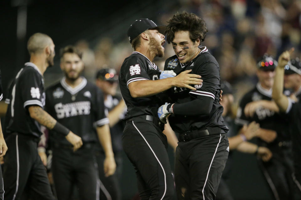 Mississippi State's Marshall Gilbert, right, is hugged by Luke Hancock after Gilbert drove in the winning run against Auburn in the ninth inning of an NCAA College World Series baseball game in Omaha, Neb., Sunday, June 16, 2019. Mississippi State won 5-4. (AP Photo/Nati Harnik)