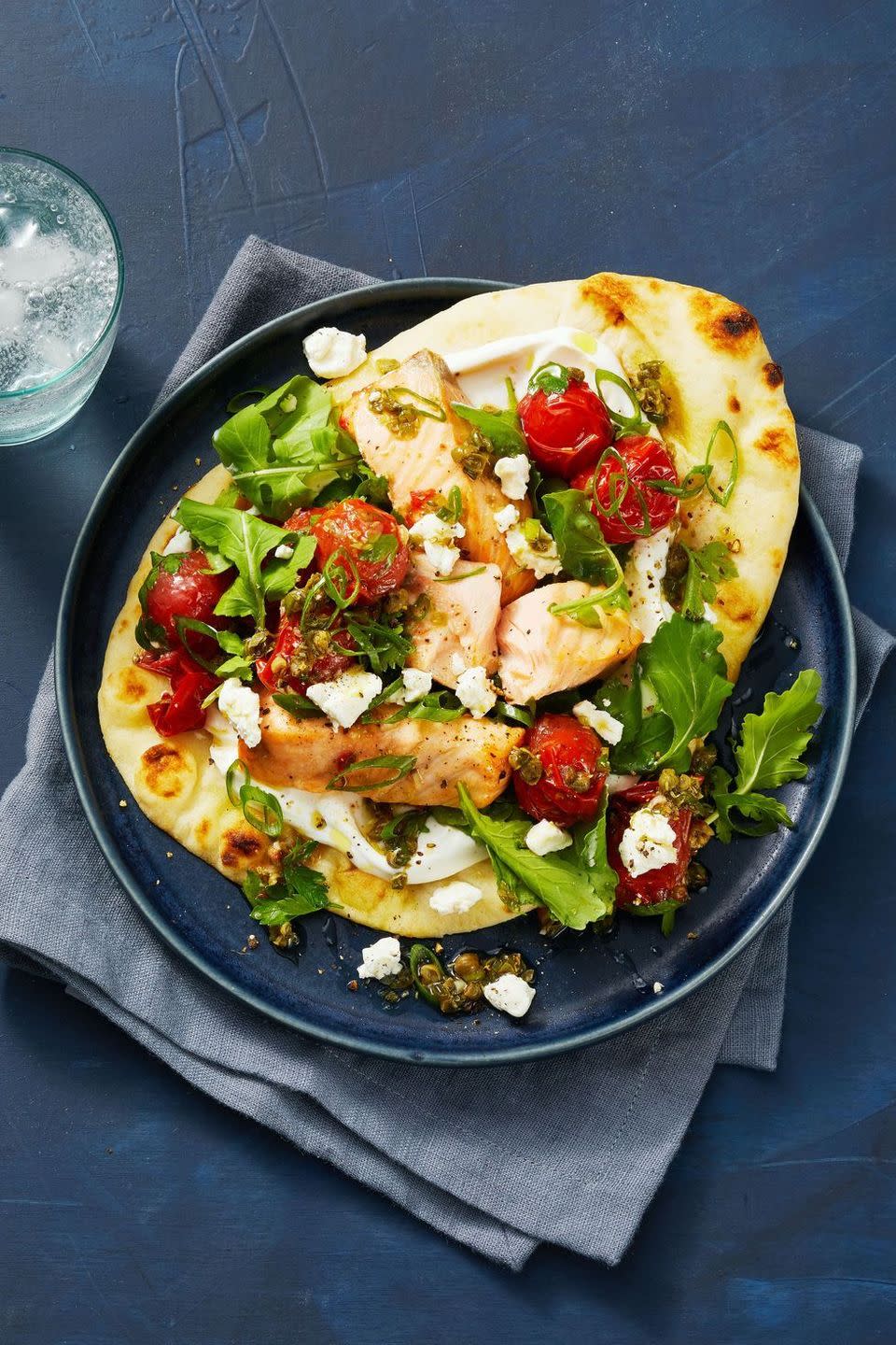 salmon with tomatoes over a pita bread