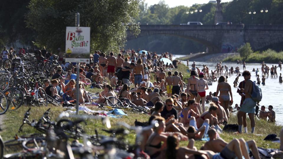 People enjoy the hot summer weather at the river Isar in Munich, Germany, Thursday, July 25, 2019. (AP Photo/Matthias Schrader)