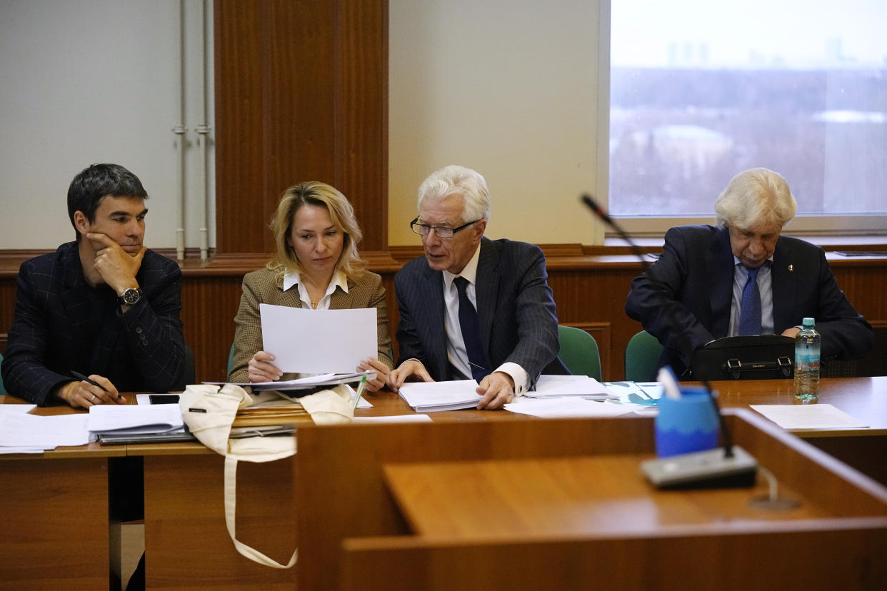 Members of the Moscow Helsinki Group and their lawyers talk in the courtroom before a hearing on the lawsuit to liquidate the Moscow Helsinki Group in Moscow, Russia, Wednesday, Jan. 25, 2023. The Moscow Helsinki Group is one of the country's oldest human rights organizations. (AP Photo/Alexander Zemlianichenko)