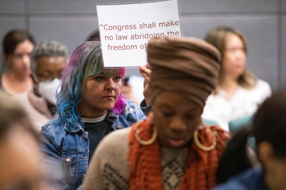 Taylor McCurdy holds a sign as she listens to speakers during a meeting on Thursday, Dec. 1, 2022 to discuss new rules that would regulate protests at the state Capitol.