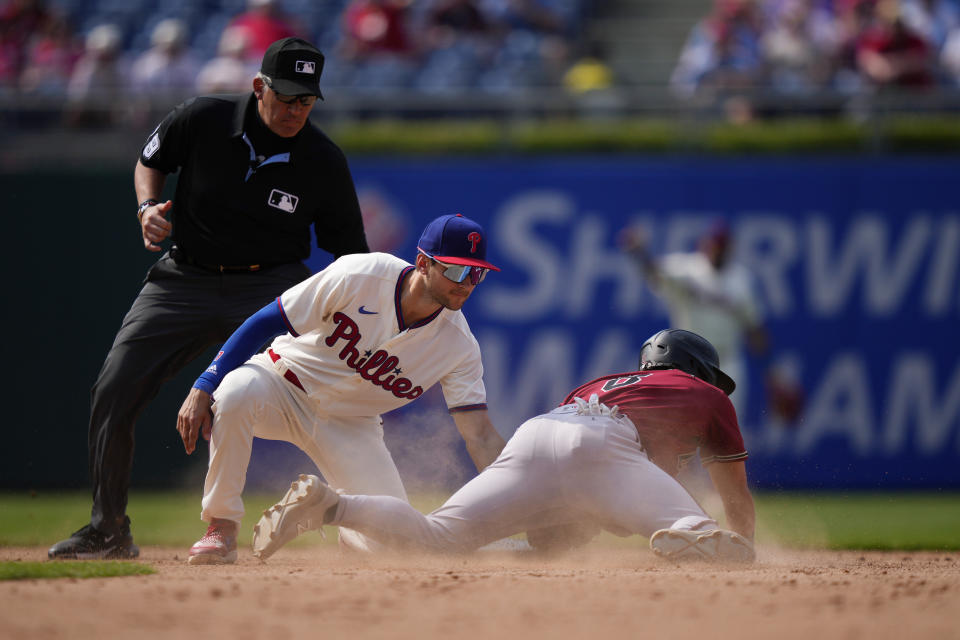 Philadelphia Phillies shortstop Trea Turner, center, tags out Arizona Diamondbacks' Dominic Fletcher, right, after he tried to steal second during the eighth inning of a baseball game, Wednesday, May 24, 2023, in Philadelphia. (AP Photo/Matt Slocum)