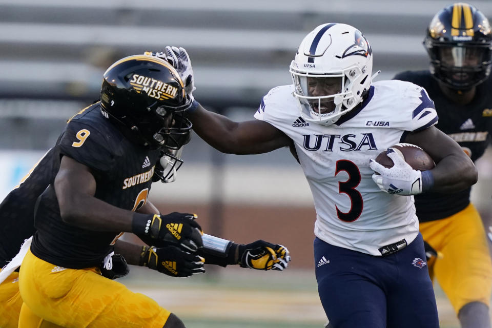 UTSA running back Sincere McCormick (3) fends off an attempted tackle by Southern Mississippi defensive back Malik Shorts (9) during the second half of an NCAA college football game, Saturday, Nov. 21, 2020, in Hattiesburg, Miss. UTSA won 23-20. (AP Photo/Rogelio V. Solis)