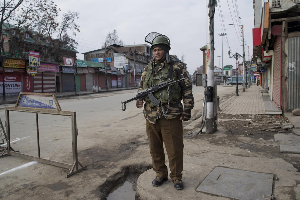 An Indian paramilitary soldier stands guard near a temporary check point during a strike in Srinagar, Indian controlled Kashmir, Sunday, Feb. 3, 2019. India's prime minster is in disputed Kashmir for a daylong visit Sunday to review development work as separatists fighting Indian rule called for a shutdown in the Himalayan region. (AP Photo/Dar Yasin)