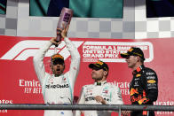 Mercedes driver Lewis Hamilton, left, of Britain, celebrates as Mercedes driver Valtteri Bottas, middle, of Finland, and Red Bull driver Max Verstappen, of the Netherlands, watch following the Formula One U.S. Grand Prix auto race at the Circuit of the Americas, Sunday, Nov. 3, 2019, in Austin, Texas. (AP Photo/Chuck Burton)