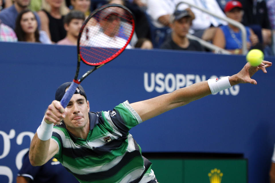 John Isner, of the United States, returns a shot to Milos Raonic, of Canada, during the fourth round of the U.S. Open tennis tournament, Sunday, Sept. 2, 2018, in New York. (AP Photo/Jason DeCrow)