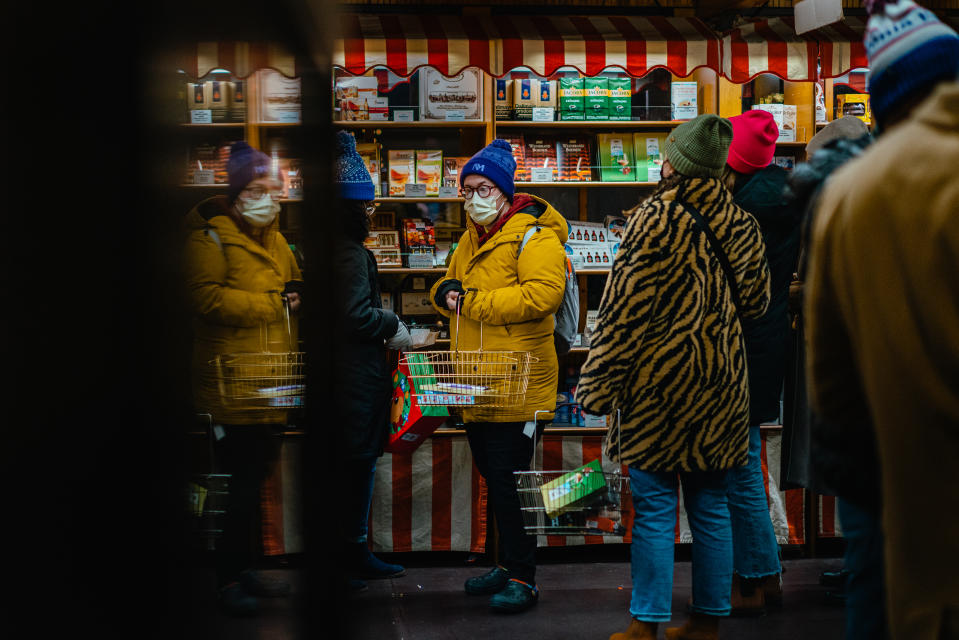 Un cliente con cubrebocas en una tienda de golosinas en el popular Christkindle Holiday Market del centro de Chicago, el 19 de diciembre de 2022. (Jamie Kelter Davis/The New York Times).