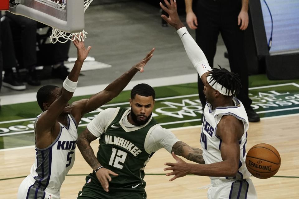 Milwaukee Bucks' D.J. Augustin passes around Sacramento Kings' Buddy Hield during the second half of an NBA basketball game Sunday, Feb. 21, 2021, in Milwaukee. (AP Photo/Morry Gash)