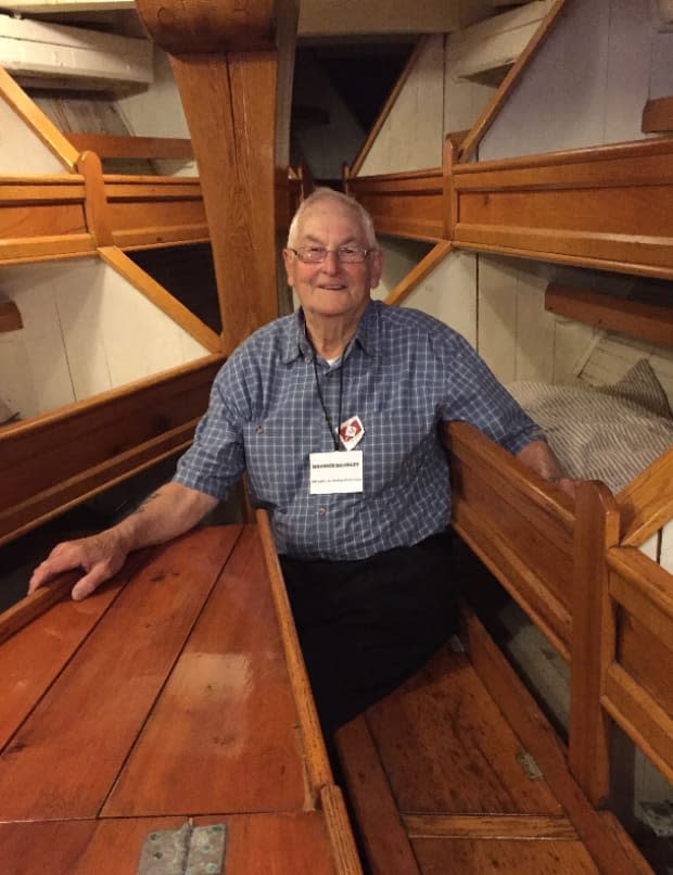 Maurice Kearley, 93, the only doryman still alive who sailed on the L.A. Dunton, has travelled to Mystic three times to see it. Here he has his arm in the bunk where he slept when he fished on it in 1953.