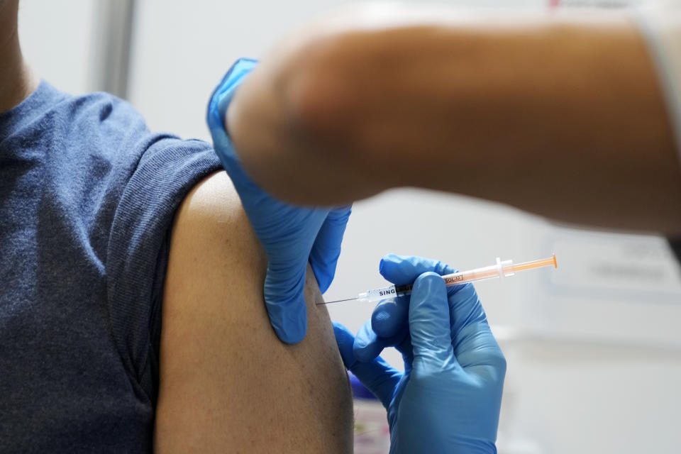 A local resident receives the booster shot of the Moderna coronavirus vaccine at a mass vaccination center operated by Japanese Self-Defense Force Monday, Jan. 31, 2022, in Tokyo. (AP Photo/Eugene Hoshiko, Pool)