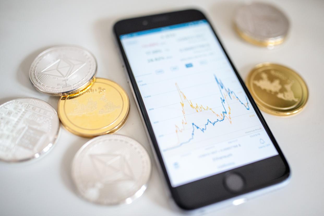 In this photo illustration of the litecoin, ripple and ethereum cryptocurrency 'altcoins' sit arranged for a photograph beside a smartphone displaying the current price chart for ethereum on April 25, 2018 in London, England.